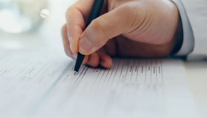 hand with pen filling in form