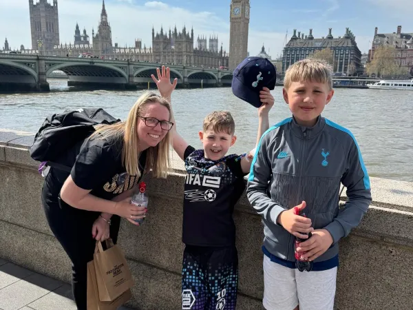 A mum and her two sons standing together with Big Ben visible behind them.