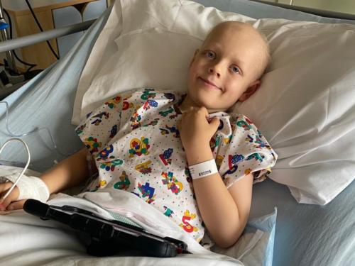 Wilf, a young boy smiling in a hospital bed