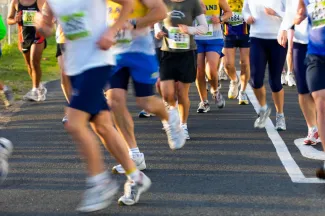A large group of runners running on road.
