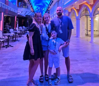 A family of four, including a mum, dad, daughter, and son, standing together for a photo.