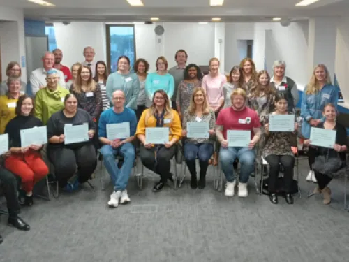A large focus group of people holding up signs that show the top ten priorities in childhood cancer research.