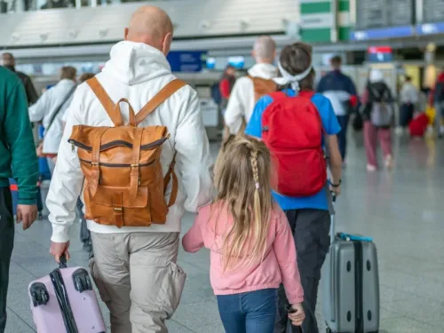 A family walking through an airport with various bags